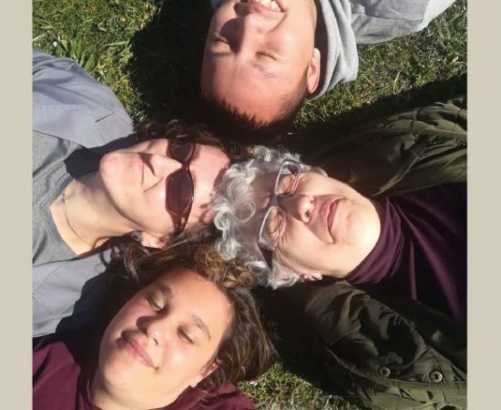 Cuatro personas de Tasubinsa, sonrientes y tumbadas en la hierba